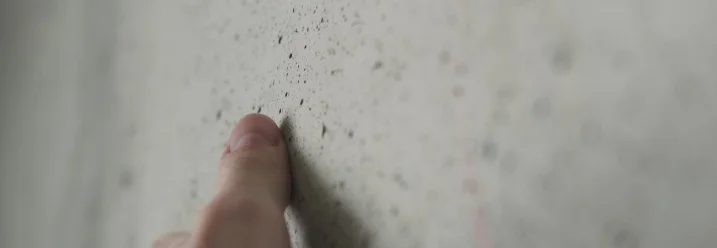 Finger berührt eine Betonwand